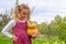 Happy proud little girl wearing a flannel dress and holding a pumpkin in a farm