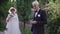 Happy proud senior man in wedding suit admiring rings and blurred woman in wedding dress at background turning looking