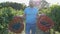 Happy proud vinedresser going at vineyard with two baskets of grapes in hands