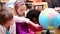 Happy pupils looking at a globe