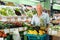 Happy purchaser with basket with fruits and vegetables