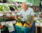 Happy purchaser with basket with fruits and vegetables