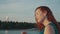 Happy red hair girl in turquoise dress on motor boat. Looking sunset. Smile.