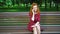 Happy red haired girl chatting joyfully on mobile phone in park