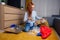 Happy redhaired ginger girl sorting waste:bottle,paper and plastic sitting at floor carpet in the living room in a