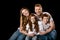 Happy redhead family sitting embracing and smiling at camera