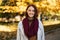 Happy redhead millennial european woman in raincoat with scarf enjoy great weather, free time in city park