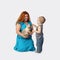 Happy redhead woman with cat on hands and little boy