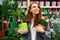 Happy redhead woman enjoy buying plants in market