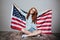 Happy redhead young lady holding USA flag