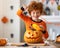 Happy redheaded boy in  costume laughs and with  spider and pumpkin Jack o lantern   during a Halloween celebration
