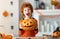 Happy redheaded boy in  costume with  pumpkin Jack o lantern   making scary faces  during a Halloween celebration