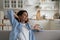 Happy relaxed woman holding cup of tea enjoying lazy day at home, taking break from daily routine