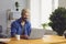 Happy remote worker typing on laptop at table at home