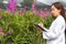 Happy researcher botanical research orchid wearing a white cap and her hand holding a pen and notebook for taking notes for resear