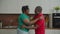 Happy retired african couple dancing in kitchen