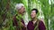 Happy retired Asian elder couple laughing under green willow tree