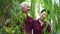 Happy retired Asian elder couple laughing under green willow tree background