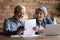 Happy retired couple do paperwork at home office at kitchen