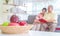 Happy retired couple reading book on a couch in living room with fresh fruit on the table to healthy eating and lifestyle