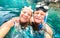 Happy retired couple with scuba mask taking selfie at tropical excursion - Boat trip snorkel experience in exotic scenarios