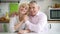 Happy retired family couple in cozy kitchen interior.