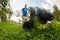 Happy retired senior person mows a lawn in his garden with a lawnmower. Garden work.