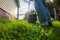 Happy retired senior person mows a lawn in his garden with a lawnmower. Garden work.