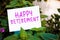 Happy retirement message written on paper on garden and plants background