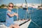 Happy rich little girl sitting aboard white luxury yacht during summer sea cruise