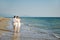 Happy romantic couple embraced walking on the beach