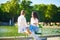 Happy romantic couple in Paris, sitting on traditional green metal chairs in Tuileries garden