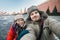 Happy romantic couple of tourists in warm clothes in winter makes a self-portrait selfie in front of the Kremlin on Red Square in