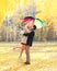 Happy romantic kissing couple in love with colorful umbrella together at warm sunny day over yellow leafs