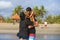 Happy and romantic mixed ethnicity couple Caucasian man and Asian Indonesian woman kissing and playing at tropical beach with