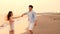 Happy Romantic young Couple dancing on the beach at sunset