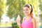 Happy runner holding water bottle looks at camera