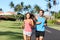 Happy runners couple having fun running training together in summer outdoors. Asian woman with personal trainer