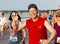 Happy runners waving during a race on a boardwalk by the beach