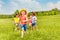 Happy running kids in green field during summer