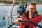 Happy sailor at the helm of his sailing yacht. Sport.