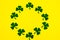 Happy Saint Patrick`s of handmade paper clover leaves on yellow background with copy space