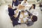 Happy sales team standing around an office table and giving each other a high five