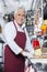 Happy Salesman Standing At Counter In Cheese Shop