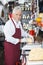 Happy Salesman Wrapping Cheese At Counter In Shop