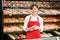 Happy Saleswoman Holding Meat Packages At Counter