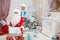 Happy Santa Claus and beautiful granddaughter with New Year`s gifts in hands in festive interior. New Year`s and