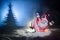 Happy Santa Claus Doll on Christmas time with tree and snow. Colorful bokeh background. Santa Clause and Merry Christmas model fig