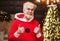 Happy Santa Claus shows thumbs up. New year advertising. Smiling Bearded man in red costume. Holidays concept.