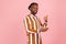 Happy satisfied afro-american man in earphones with dreadlocks in striped shirt showing thumbs up using mobile application to